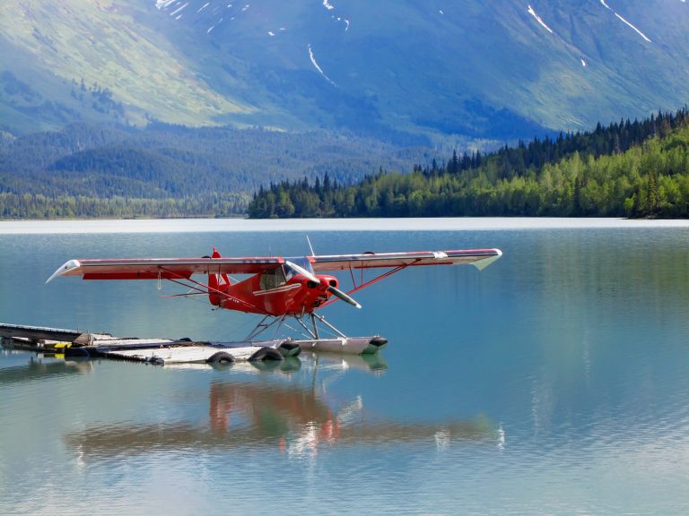 Cessna float plane sits at dock in early morning light.