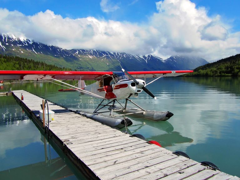 Cessna float plane sits at dock in early morning light.
